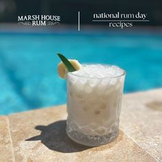 a close up of a drink on a table near a swimming pool with the words marsh house rum and national rum day recipes