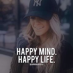 a woman wearing a new york yankees hat with the words, happy mind happy life