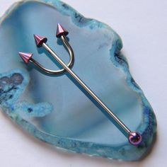 a blue agate with two pink spikes and an arrow on it's end