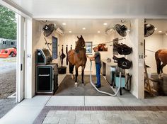 an open garage with horses and other things on the wall, in front of it