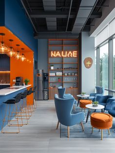 the interior of a restaurant with blue chairs and orange bar stools in front of large windows