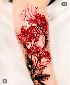 a woman's arm with red flowers on it and black ink in the middle