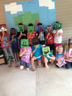 a group of children holding up blocks in front of a wall