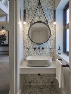 a white sink sitting under a mirror next to a wall mounted faucet in a bathroom