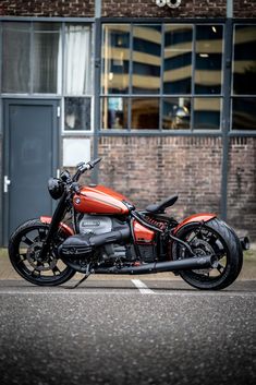 an orange motorcycle parked in front of a building