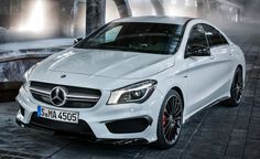 a white mercedes cla parked in front of a fountain