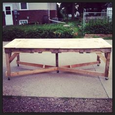 a wooden table sitting on top of a sidewalk