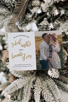 an ornament hanging from the top of a christmas tree with a photo on it