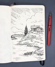 an open notebook with a drawing of a house on the side and a pen next to it