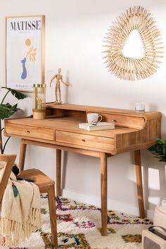 a wooden desk with a mirror on the wall above it and a chair next to it