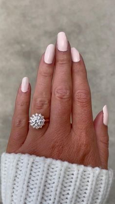 a woman's hand with pink manicured nails and a ring on her finger