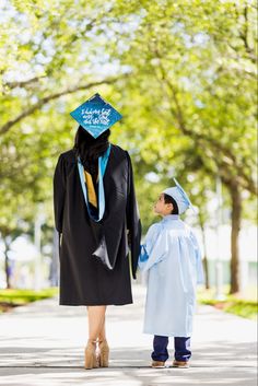 a woman in a graduation gown walking with a child