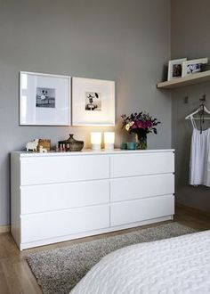 a white dresser with flowers and pictures on it