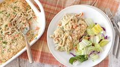 two plates of food on a table with utensils