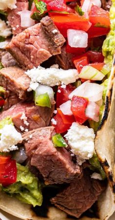 steak, tomato and lettuce salad with feta cheese on tortilla