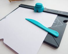 a piece of paper with a blue pen on top of it next to some scissors