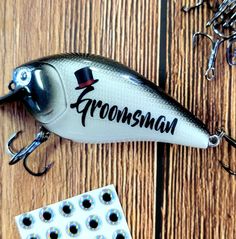 a fishing lure sitting on top of a wooden table next to some hooks and magnets