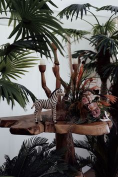 there is a zebra that is standing on a table next to some plants and candles