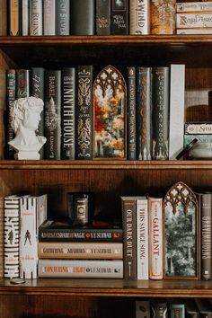 several books are stacked on top of each other in a wooden shelf with decorative decorations