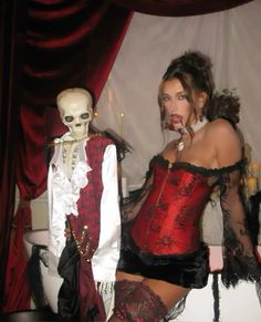 two mannequins dressed up in costumes with red and black lace on them