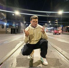 a man sitting on top of a wooden bench in the middle of an empty street