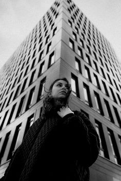 a woman standing in front of a tall building