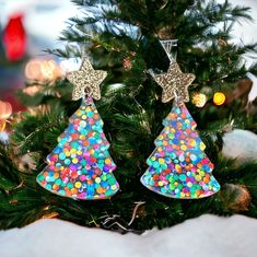 the christmas tree is decorated with multicolored confetti and star shaped earrings