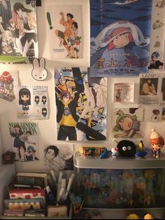 the wall is covered with anime posters and other items, including figurine heads