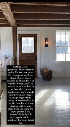 the inside of a house with an open door and white walls, wood beams on the ceiling