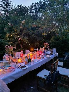 an outdoor dinner table with candles and flowers