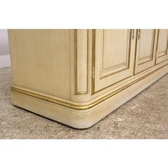 a close up view of the bottom of a cabinet with marble flooring and beige walls