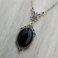 This Gothic Black Crystal Charm Necklace is not just a stunning, edgy butterfly necklace for women. It's a unique piece of gothic jewelry, featuring a dark crystal charm in the shape of a butterfly with embossed vampire and witch details. This necklace is perfect for those who want to stand out with their mystical, macabre style. The black choker necklace has a vintage look with its delicate chain and antique-inspired charm. Wear this witchy, spooky accessory for a bewitching boho or punk rock l Edgy Butterfly, Women Vampire, Necklace Butterfly, Dark Crystal, Goth Look, Black Choker Necklace, Victorian Goth, Vintage Choker, Witch Jewelry