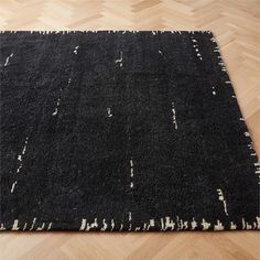 a black and white rug on a wooden floor