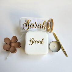 a jar with some writing on it next to a candle and flower pot filled with candles