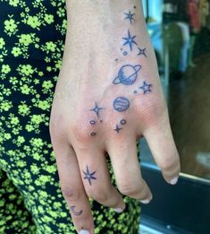 a person with tattoos on their fingers and hand