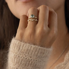 a close up of a person wearing a ring on their finger and holding the other hand