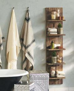 a bath room with towels hanging on the wall and a tub in the corner next to it