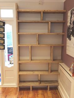 an empty bookcase in the corner of a room next to a heater and radiator