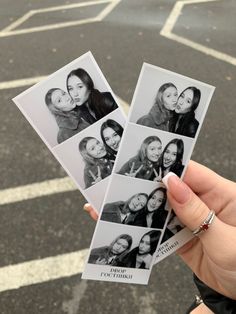 a person holding up four polaroid pictures in front of a parking lot with white lines on the ground