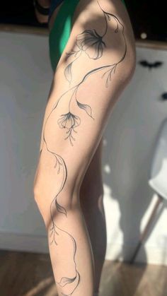 a woman's legs with tattoos on them, and her leg in the shape of flowers