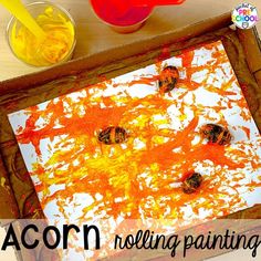 the acorn painting is being made with orange and yellow paint, while other paints are on