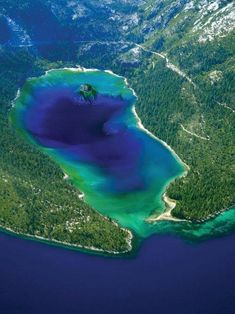 an aerial view of the blue water and green land in the middle of the ocean