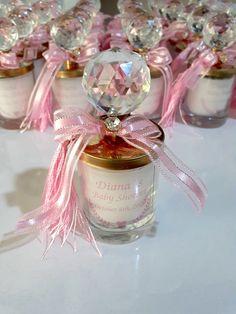 several small jars filled with pink and white candles