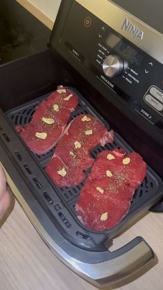 four pieces of meat are being cooked in the oven