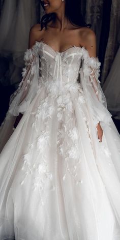 a woman in a white wedding dress with flowers on it