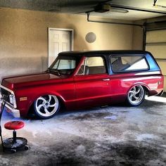 an old red station wagon parked in a garage