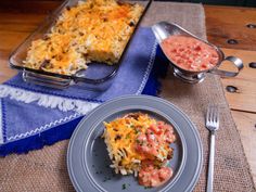 a plate with some food on it next to a casserole dish and spoon