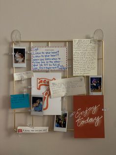 a bulletin board with pictures and notes attached to the back of it, hanging on a wall