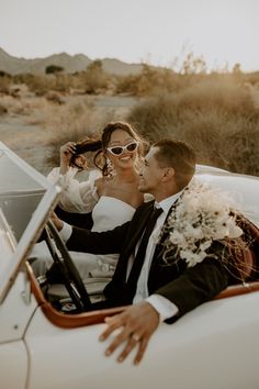 a bride and groom are sitting in the back of a white convertible car with their arms around each other