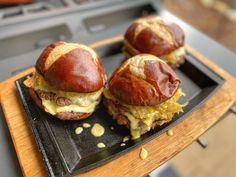 two cheeseburgers are sitting on a black plate